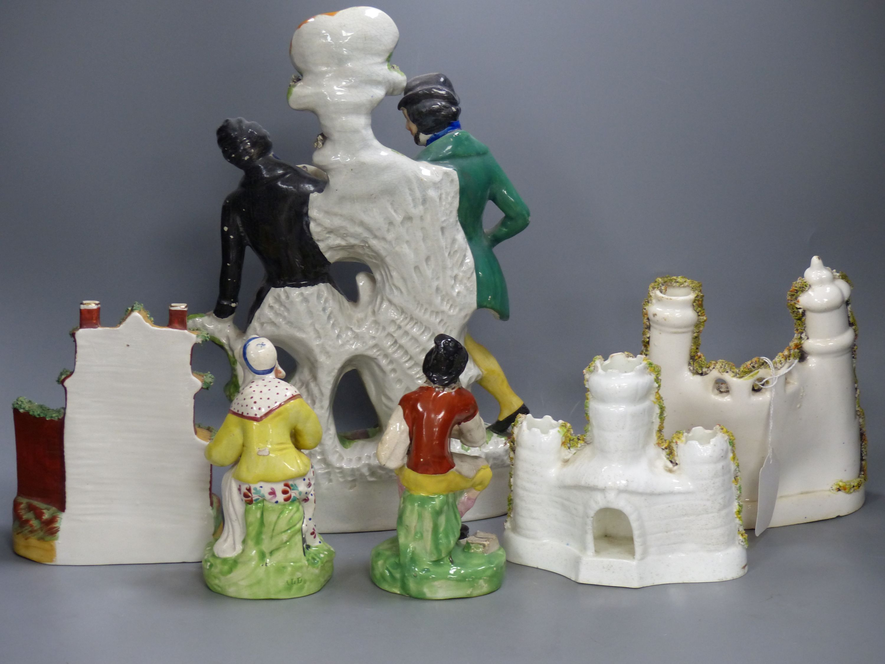 A pair of 19th century Staffordshire figures, 'Jobson' and 'Nellie', two castle flatback groups, a cottage pastille burner and a Gamekeeper and Poacher spill vase (6)